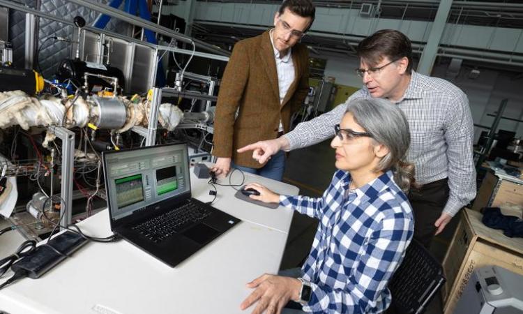 <p>Postdoctoral fellow Poorandokht Kashkouli, seated, discusses test data from their direct air capture rig with Ryan Lively, left, and Chris Jones. The system pulls air across filter materials to remove carbon dioxide. (Photo: Candler Hobbs)</p>